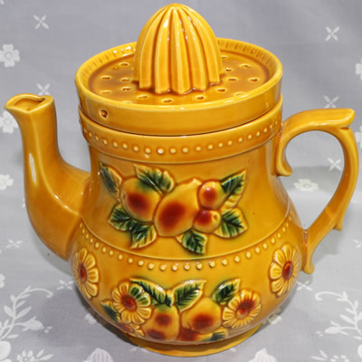 Tan teapot shape juicer with relief fruit and flowers