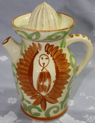 A primitive image in brown on a beige ceramic juicer