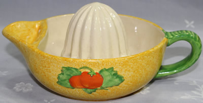 Red fruit with green leaves on 1 piece sponged yellow juicer