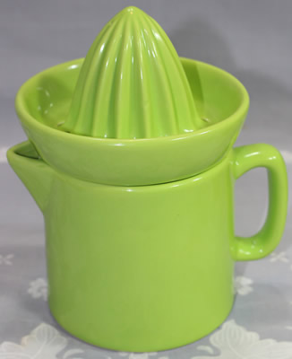 A 2 piece lime green ceramic jug juicer