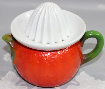 Red jug with green handle and white top ceramic juicer