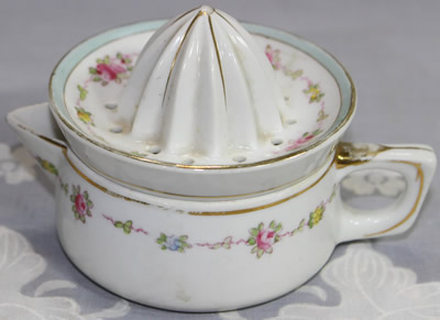 A small garland of flowers and gold trim white juicer