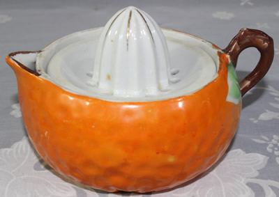 Hand painted green leaves on an orange pear shape juicer