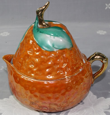 Orange coloured pear shape, green leave and gold trim juicer