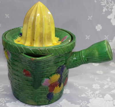 Large green, with yellow, pink, blue and tan pot like juicer