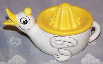 White duck with yellow bill and yellow juicer top