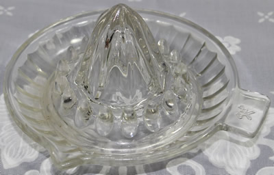 A crossed hammer and sword clear glass saucer shape juicer