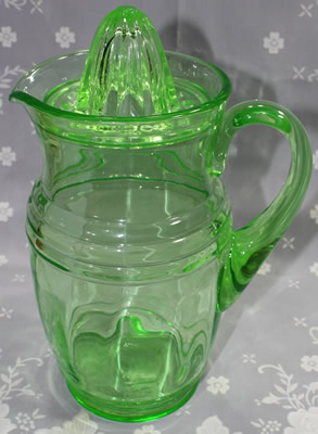 A large U.S. Glass Company green glass jug juicer with lid