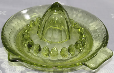 A smaller hobnail green glass saucer shape juicer