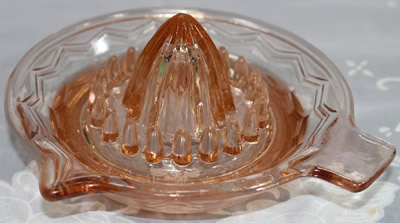 Pink glass zig-zag pattern saucer shape juicer