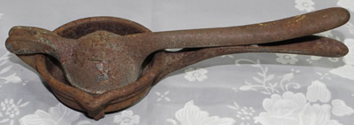 Embossed "L F & C" iron squeezer with feet