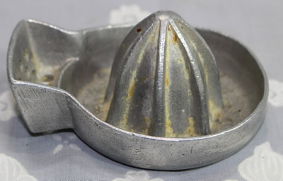 An aluminium saucer shape juicer with a side mounted drain