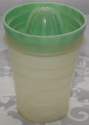 Green juicer on white translucent plastic tumbler