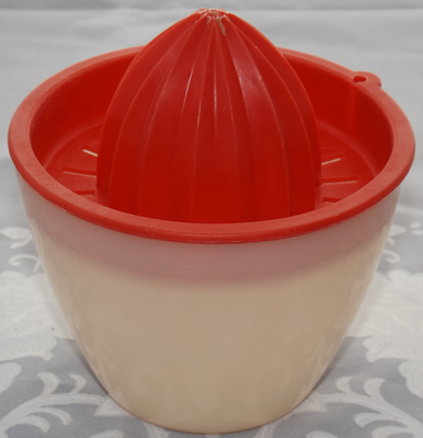 Red plastic juicer on Tupperware bowl