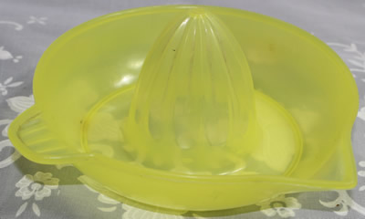A transparent yellow plastic left handed juicer
