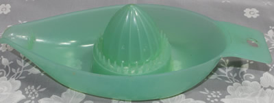 A translucent aqua green Marquis plastic boat shape juicer