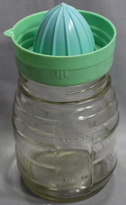 Pastel green plastic juicer on glass jar