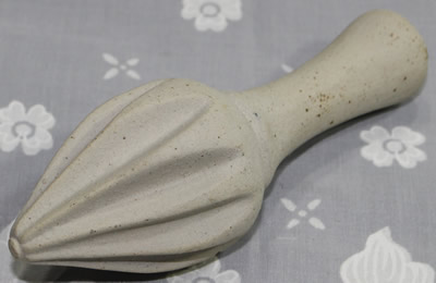 An unglazed pottery reamer juicer