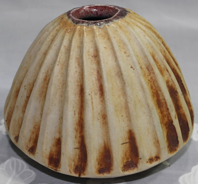 A pottery candle holder that looks like a juicer